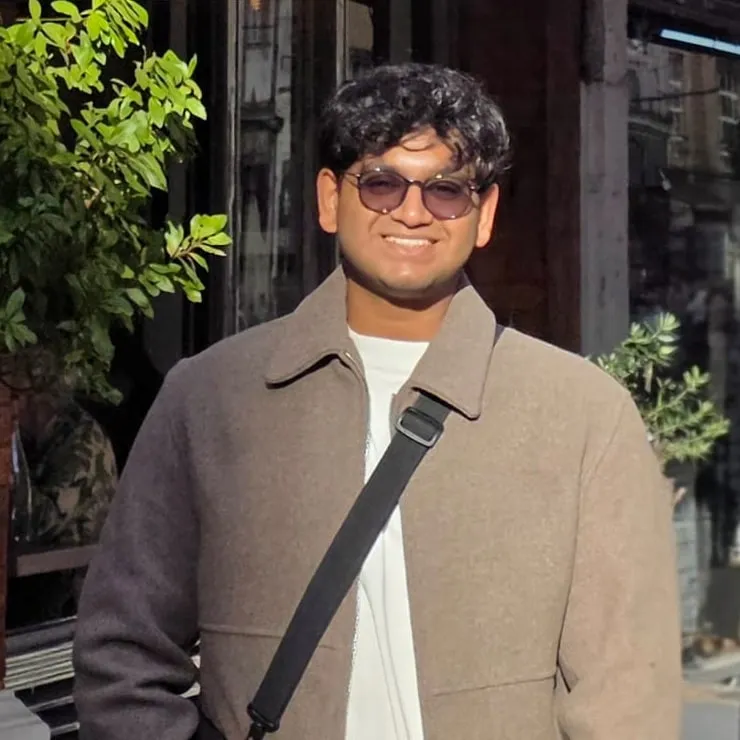 Piyush Mohapatra on a London street, smiling, with a camera in hand